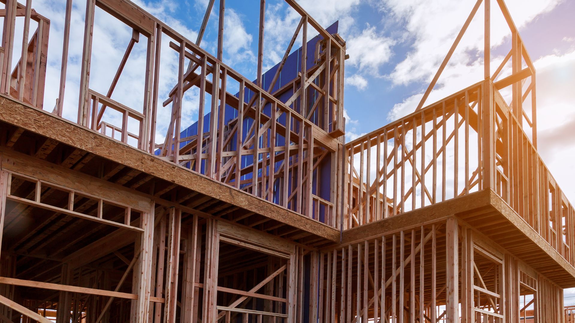 A house under construction under a cloudy blue sky