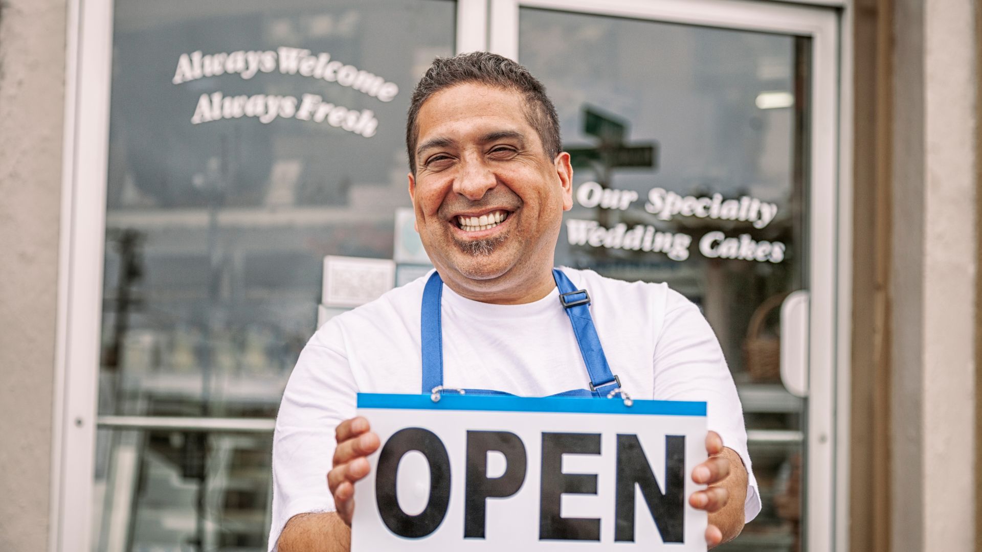 A man holding a sign that says open