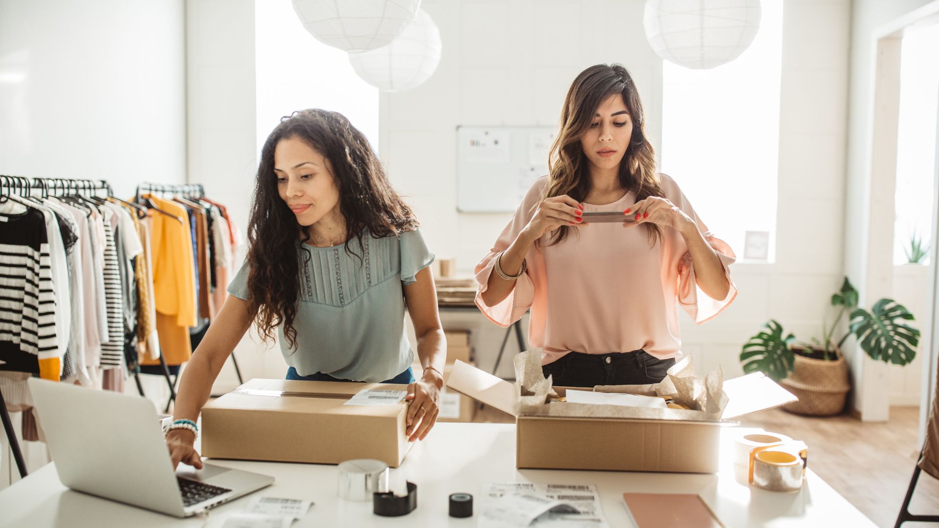 Two women in a clothing store looking at a box