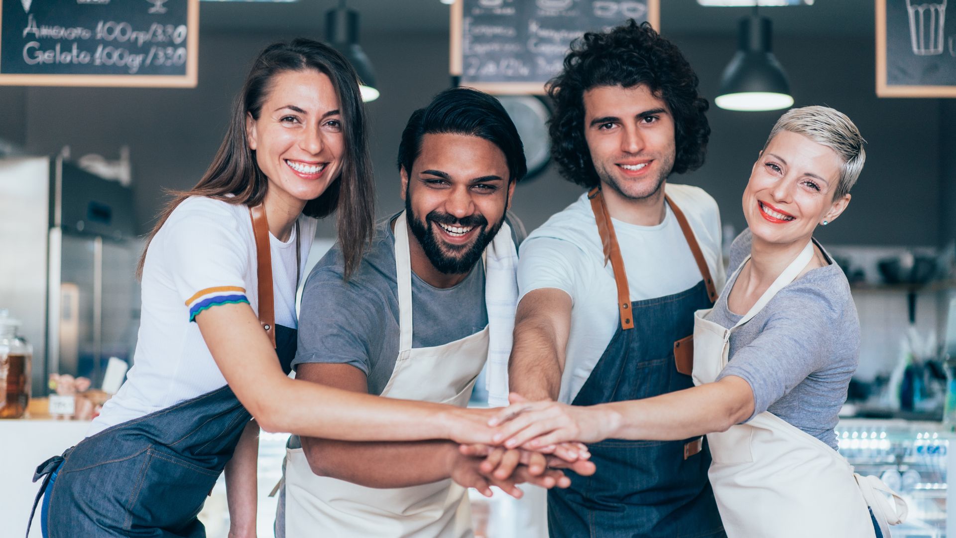 A group of people holding hands in a kitchen